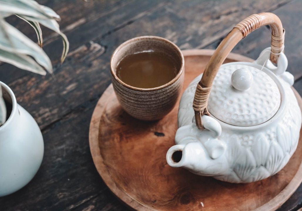 white and brown ceramic teapot on wooden tray
